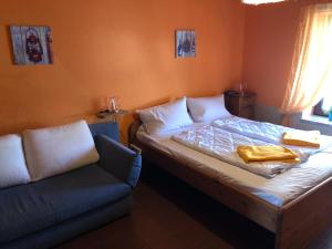 um pequeno quarto com uma cama e um sofá em Villa Kunterbunt Ostsee em Schashagen