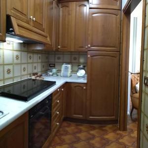 a kitchen with wooden cabinets and a stove top oven at Casa di nonna Cate in Montepulciano