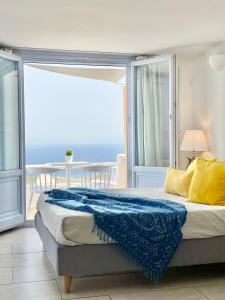 1 dormitorio con 1 cama y vistas al océano en Elkaza Villas, en Fira
