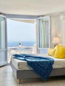 a bedroom with a bed with a view of the ocean at Elkaza Villas in Fira +42 photos