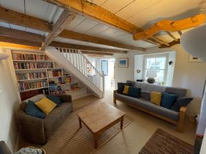 uma sala de estar com dois sofás e uma estante de livros em Mapa Cottage em Mount Hawke