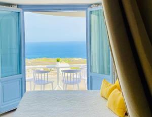 a bedroom with a bed and a view of the ocean at Elkaza Villas in Fira