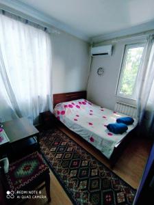 ein kleines Schlafzimmer mit einem Bett und einem Fenster in der Unterkunft Rose House in Tbilisi City