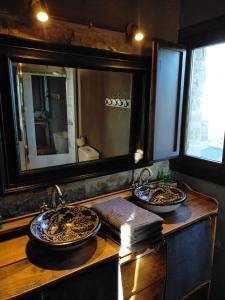 a bathroom with two sinks and a mirror at A Boira Rural in Osia