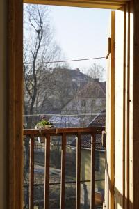 an open window with a plant on a balcony at Modiste in Kuldīga