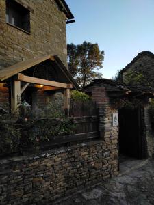 a brick building with a wooden door and a fence at A Boira Rural in Osia