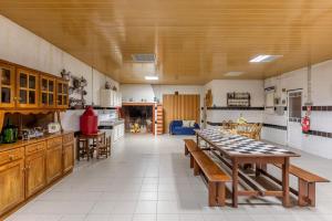 a large kitchen with a table and some chairs at Quinta da Pinheira Lezíria in Alpiarça