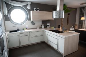uma cozinha com armários brancos e uma janela em Monopol Apartments em Wernigerode