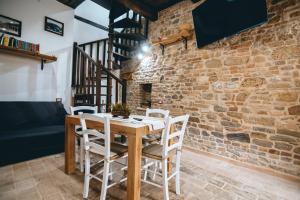a dining room with a wooden table and white chairs at Casa - Il Gioiello - con Jacuzzi e Sauna in Amandola