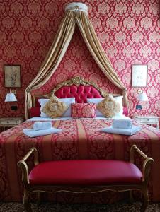 1 dormitorio con cama roja y dosel en Luxury Suites in Venice-Friendly Venice Suites, en Venecia