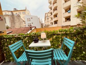 2 sillas y mesa con lámpara en el balcón en Nice Renting - PAGANINI - Spacious Apartment - 2 BedRooms - King Bed - Bathtub - Heart of Nice en Niza