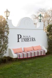 a bench sitting in the grass in front of a sign at Quinta da Pinheira Lezíria in Alpiarça