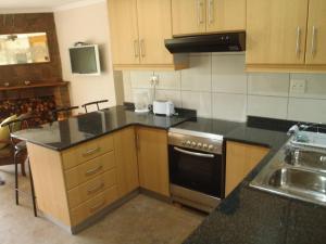 a kitchen with wooden cabinets and a stove top oven at Berg Treat in Champagne Valley