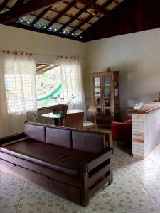 a living room with a couch and a table at Chale no centro de Lumiar com água de nascente in Nova Friburgo