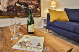 a bottle of wine and two glasses on a table at La Venelle des Greniers à Sel in Honfleur