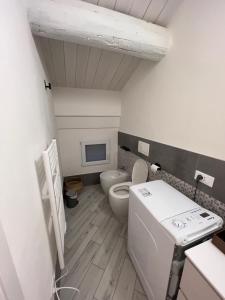ein kleines Bad mit einem WC und einem TV in der Unterkunft [Ferrara Centro - WABI APT] in Ferrara