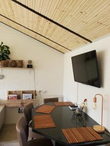 a dining room with a table and a flat screen tv at Vakantiehuis Elisa Zuid Limburg in Simpelveld