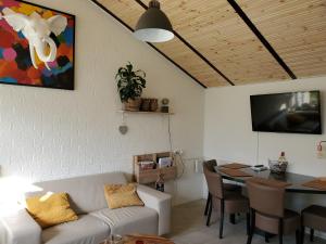 a living room with a couch and a dining room table at Vakantiehuis Elisa Zuid Limburg in Simpelveld