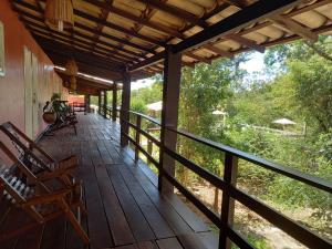 a porch of a house with chairs and trees at Pousada Canto das Aguas in Serra do Cipo