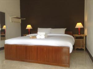 a bedroom with a large bed with towels on it at Space Ben Guest House @ Muangkao in Sukhothai