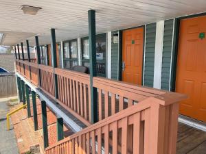 un porche de una casa con puertas de color naranja y verde en Atlantic Shores Inn and Suites, en Chincoteague