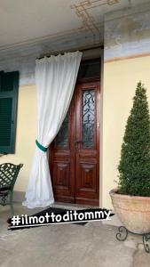eine Tür mit einem Vorhang und einem Baum davor in der Unterkunft il Motto di Tommy in Castelveccana