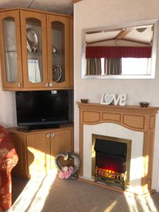 sala de estar con chimenea y TV en Lovely 3 bedroom 8 berth caravan in Rhyl, en Rhyl