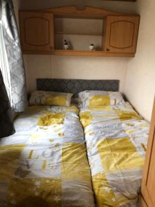two beds sitting next to each other in a room at Lovely 3 bedroom 8 berth caravan in Rhyl in Rhyl