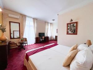 una camera d'albergo con un grande letto e una TV di Manjež Centar a Belgrado
