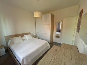 a bedroom with a white bed and a pendant light at Magic Apartments in Bardolino