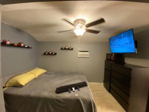 Un dormitorio con ventilador de techo y televisión. en Cozy House, en Fort Lauderdale