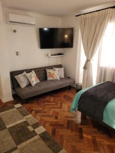 uma sala de estar com um sofá e uma televisão de ecrã plano em Los Araucanos em Santiago
