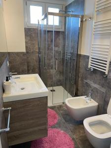uma casa de banho com um lavatório, um WC e um chuveiro em Magic Apartments em Bardolino