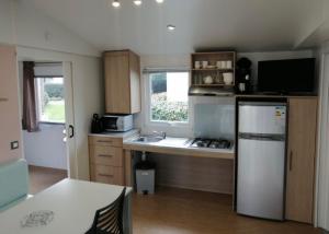 a kitchen with a white refrigerator and a counter top at Mobilhome 4/6 pers à 600m de la plage des Conches in Longeville-sur-Mer