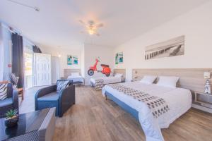 a bedroom with a bed and a motor scooter on the wall at Hôtel Land'Azur in Mimizan-Plage