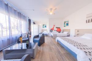 a bedroom with a bed and a living room at Hôtel Land'Azur in Mimizan-Plage