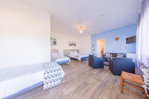 a bedroom with two beds and a living room at Hôtel Land'Azur in Mimizan-Plage