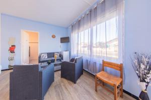 a living room with blue walls and a large window at Hôtel Land'Azur in Mimizan-Plage