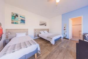 a bedroom with two beds in a room at Hôtel Land'Azur in Mimizan-Plage