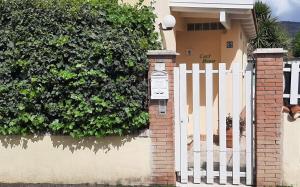 a white fence in front of a house at Cozy House in Tivoli