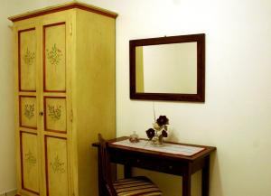 Habitación con mesa y espejo en la pared. en Case Vacanze Valle, en Lipari