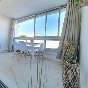 Blue Sky La Grande Motte Studio -Pool-5min Beach -Queensizebed -WiFi في لا غراند موت: غرفة طعام مع طاولة وكراسي ونافذة