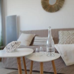 two tables with wine glasses and a bottle on them at Blue Sky La Grande Motte Studio -Pool-5min Beach -Queensizebed -WiFi in La Grande-Motte