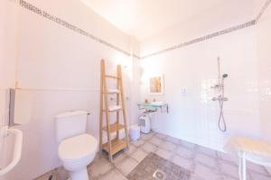 a white bathroom with a toilet and a shower at Hôtel Land'Azur in Mimizan-Plage
