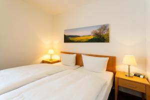 a bedroom with two white beds and two lamps at Nixe - Villa Helene mit Meerblick in Top Lage in Binz