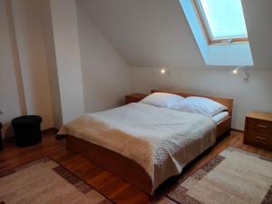 una camera da letto con un letto con lenzuola bianche e una finestra di Apartamenty Kołczewo a Kołczewo