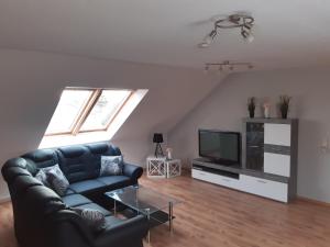 a living room with a couch and a tv at Ferienwohnung Günther am Park in Ditfurt