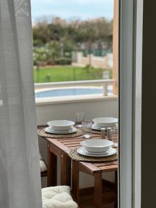 una mesa con platos y vistas a la piscina en APARTAMENTO TOTALMENTE NUEVO JUNTO AL MAR - Cabo de Gata en Retamar