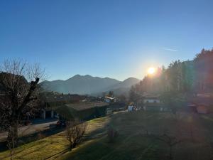 una vista de un pueblo con la puesta de sol detrás de las montañas en Beim Mühltaler, en Schleching