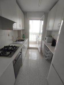 a kitchen with white cabinets and a stove top oven at La Manga Estacio in San Blas